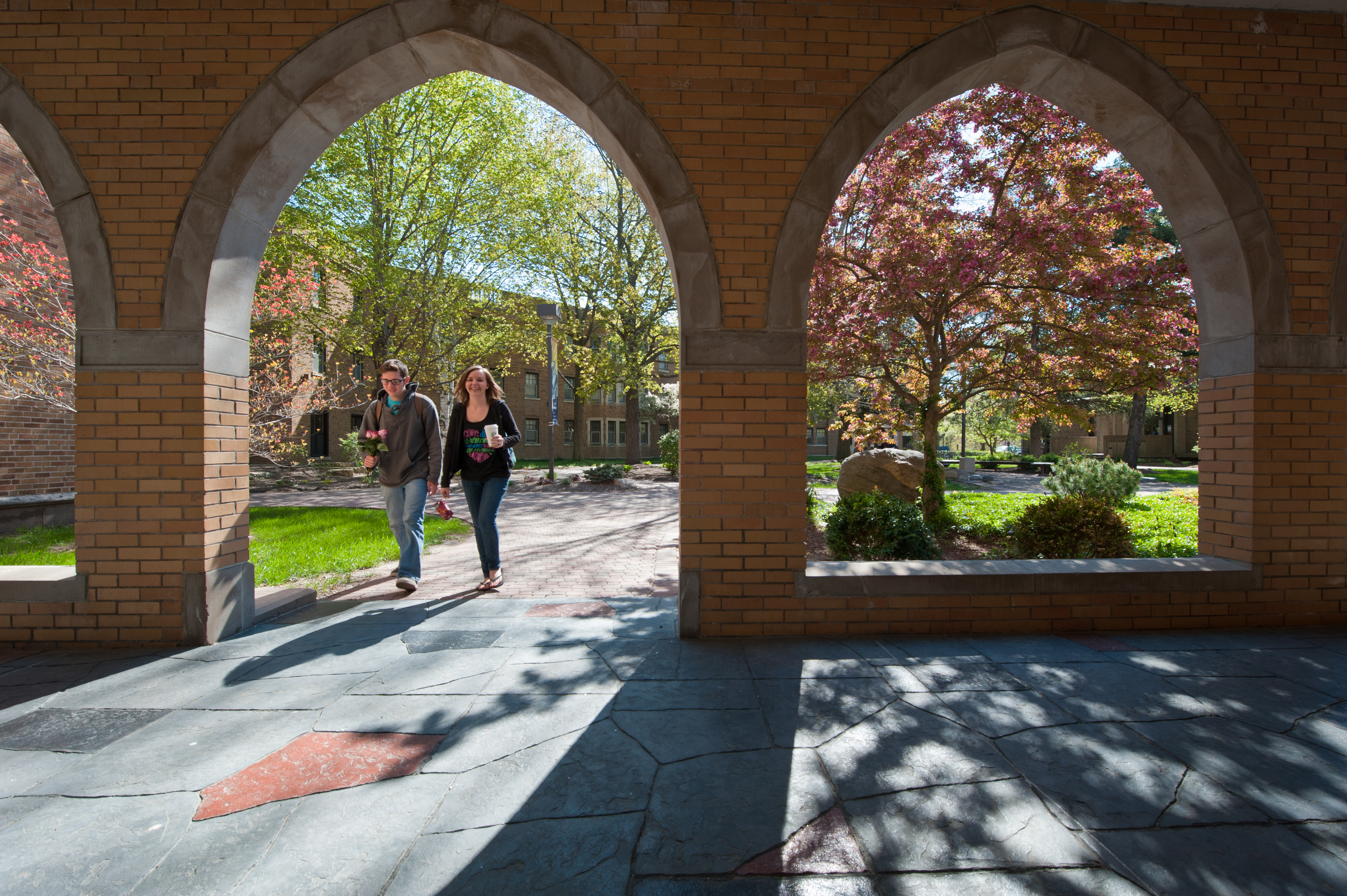 students walking under the arches of Founders Hall