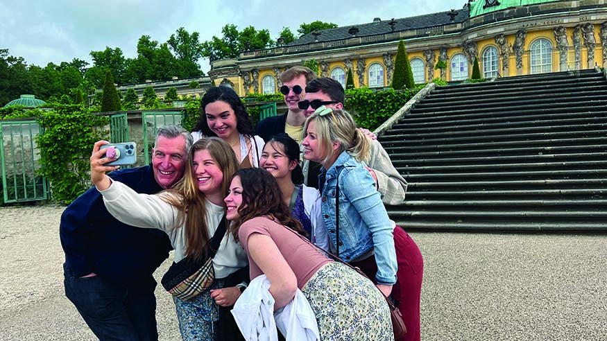 Augustana Choir Director Dr. Jon Hurty and students outside Sanssouci Palace in Potsdam, Germany.