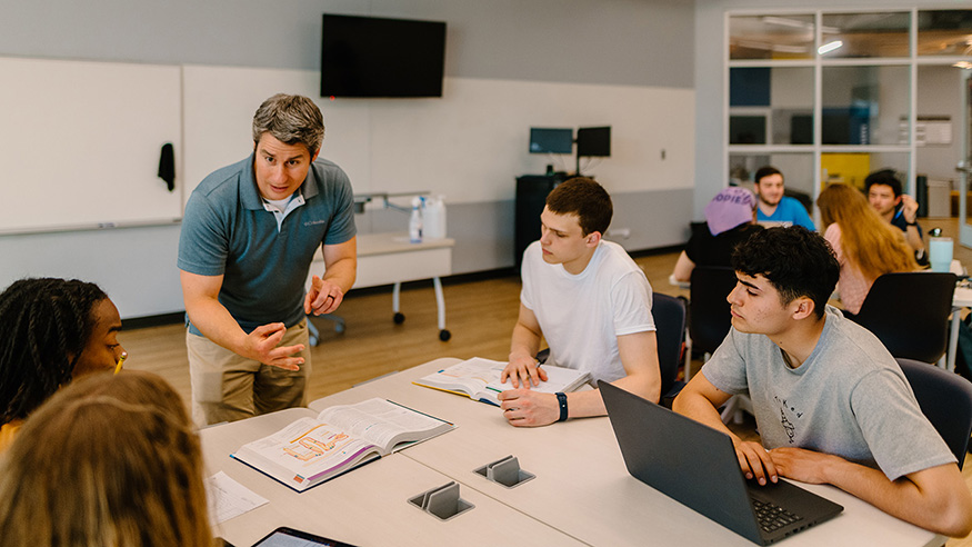 A professor talking to a group of students in a classroom