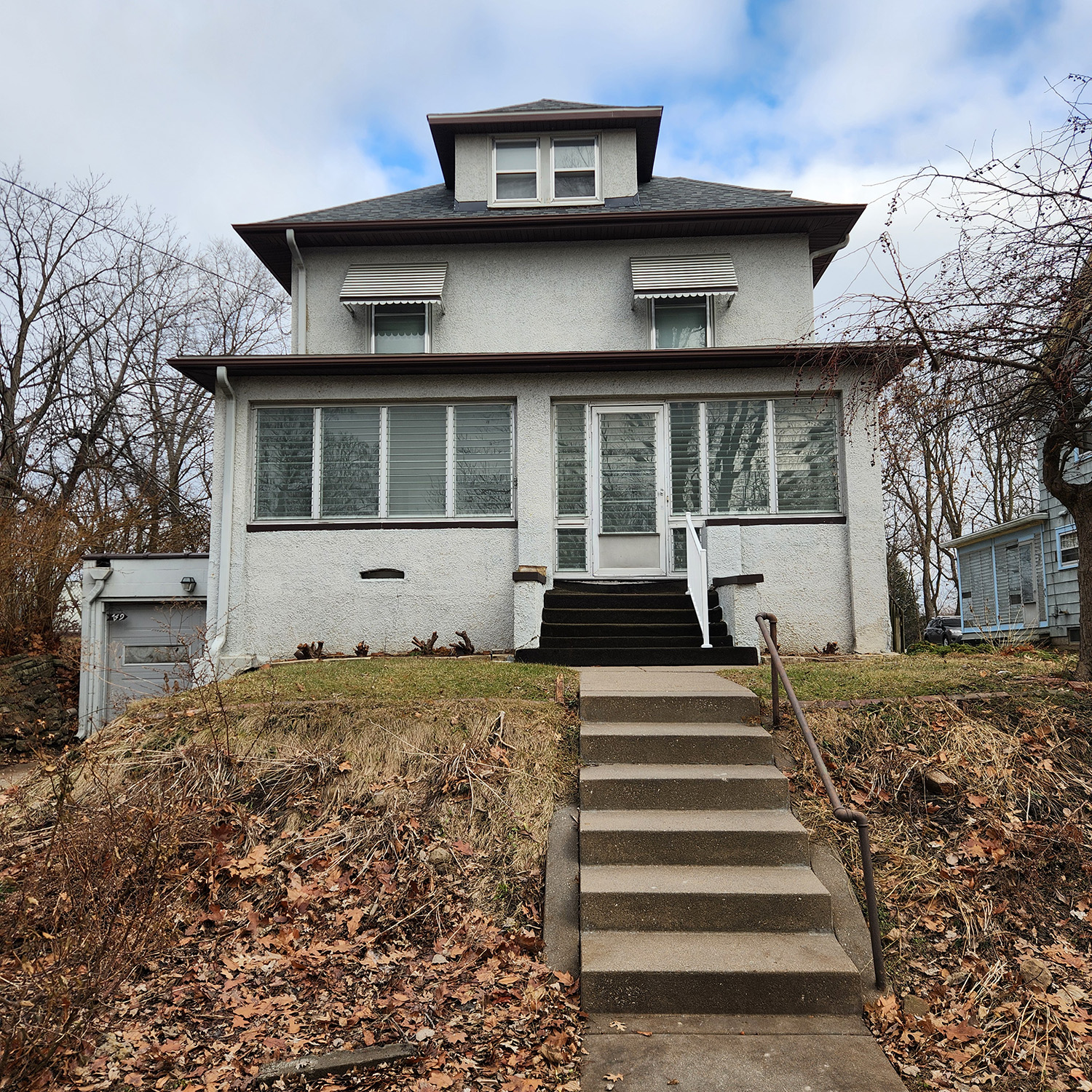 Campbell House front view. A white multi-story house with stairs leading to the front entrance