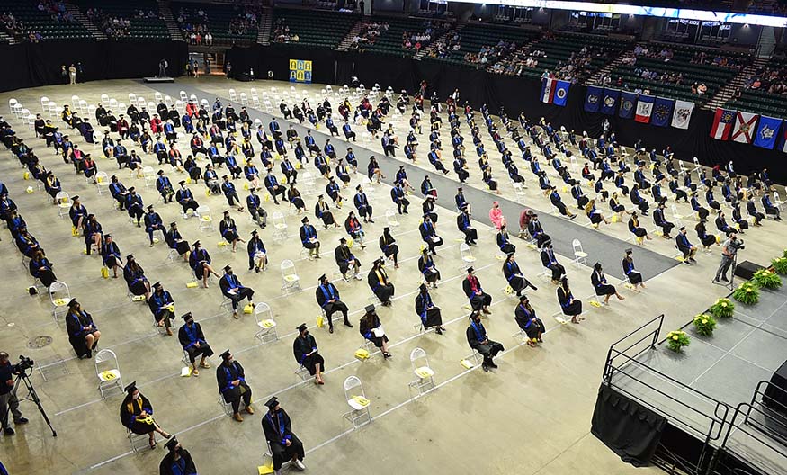 Graduates seated on floor of arena.