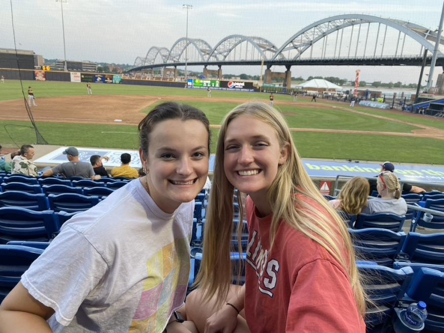 Jenny and a friend smiling for a photo at a River Bandits game.