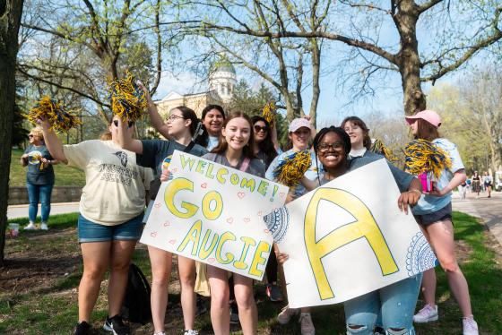 Augustana College students holding signs welcoming visitors