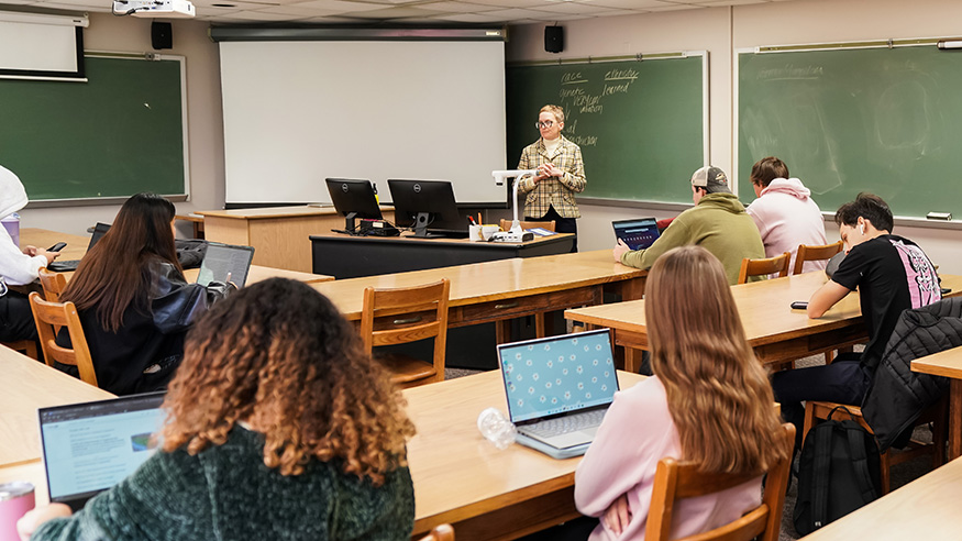 A professor presenting in a classroom of students