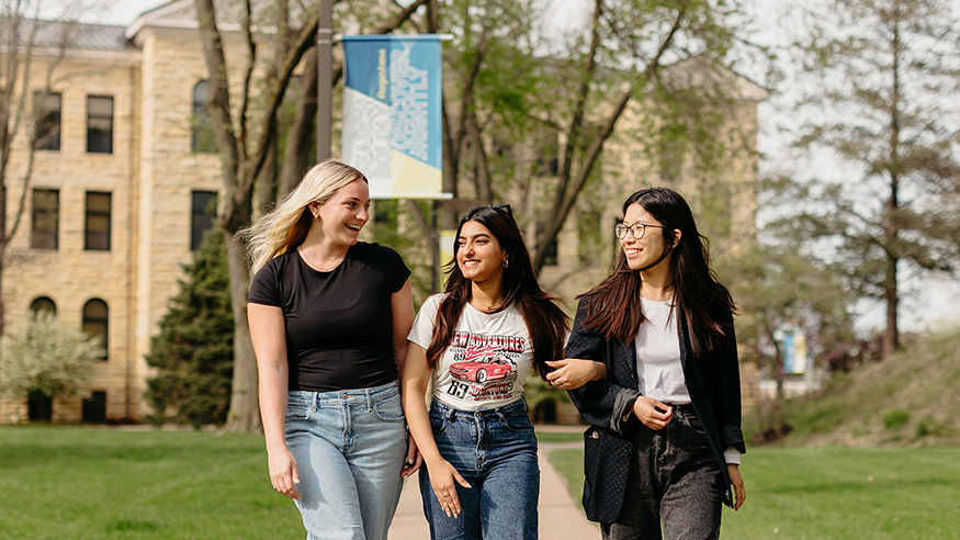 Three girls walking in the Quad