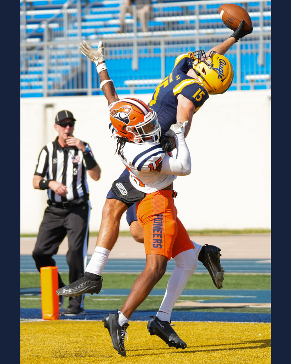 Augustana football player jumping to catch a football as a referee blows a whistle in the background