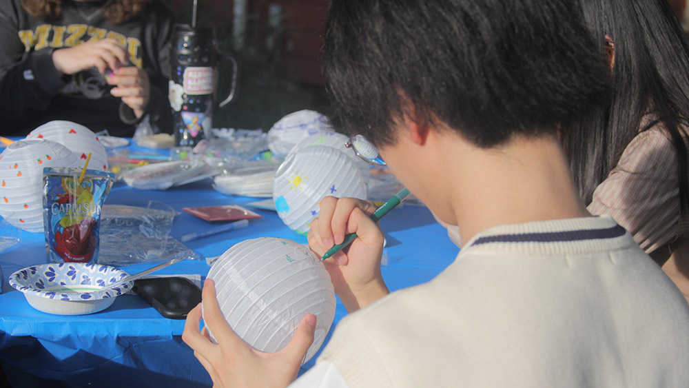 Student decorating a paper lantern