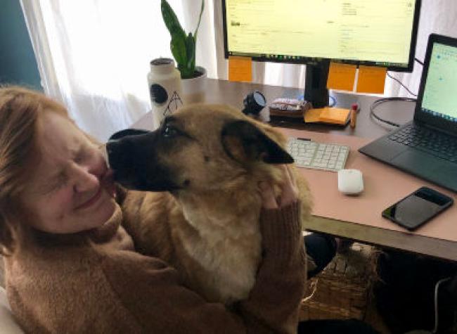 Amanda getting kissed by her fluffy dog.