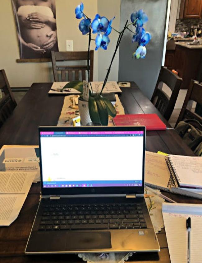 Tia Fuhr shows laptop with blue flowers in a vase