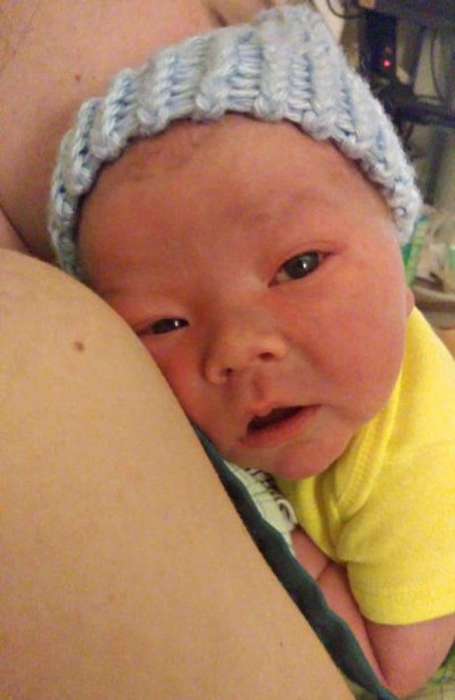 baby Jack laying on Amber's (mom) shoulder looking at the camera