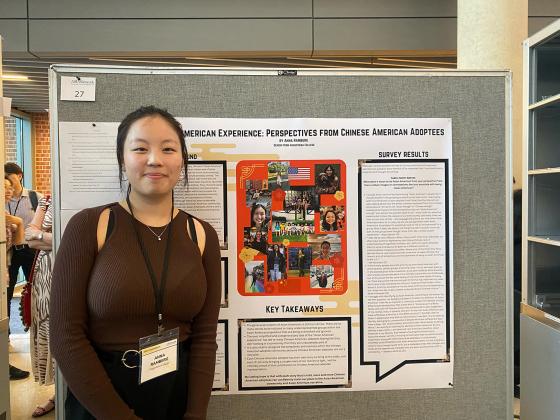 A women standing in front of a poster board with research findings