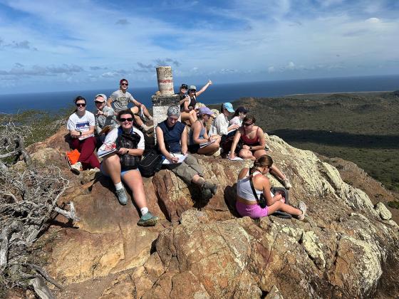 a few students sitting on a rock